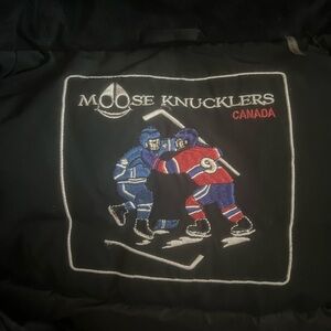 Moose Knuckles Black Jacket with Blue and Red Hockey Embroidery
